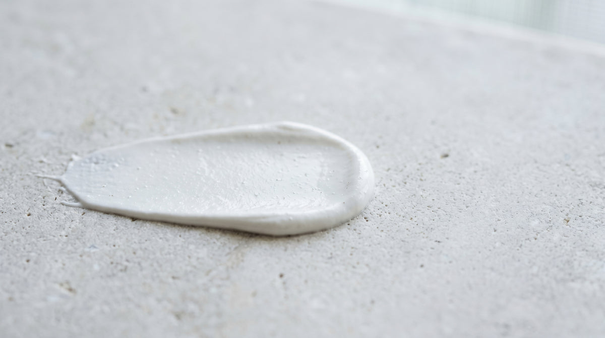 Swatch of white non-nano zinc oxide mineral sunscreen cream on a pale surface