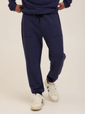Men wearing navy blue relaxed fit FeatherLoop fleece joggers in a minimalist athleisure style