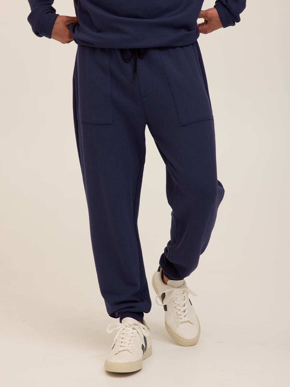 Men wearing navy blue relaxed fit FeatherLoop fleece joggers in a minimalist athleisure style