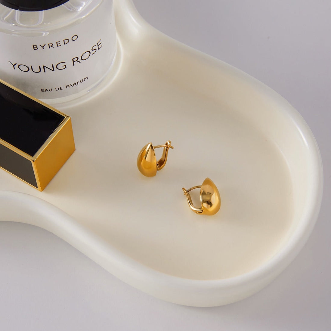 Elegant teardrop-shaped 18K gold earrings with smooth, minimalist lines