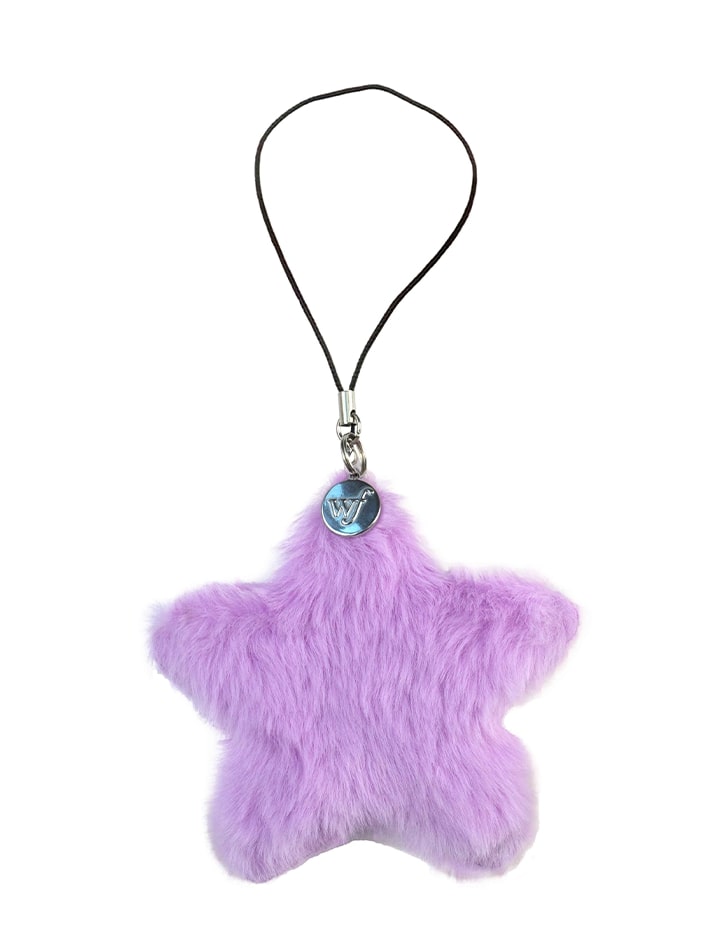 Purple plush star-shaped charm with a black loop string and silver wildflower branded tag