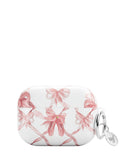 White AirPods case decorated with pink ballet shoes and ribbon pattern including a silver ring keychain.