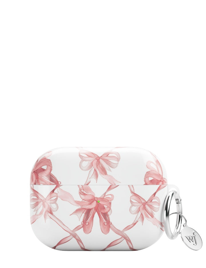 White AirPods case decorated with pink ballet shoes and ribbon pattern including a silver ring keychain.