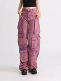 Model wearing pink acid wash high waist wide leg patchwork cargo jeans with multiple pockets, paired with a black crop top.