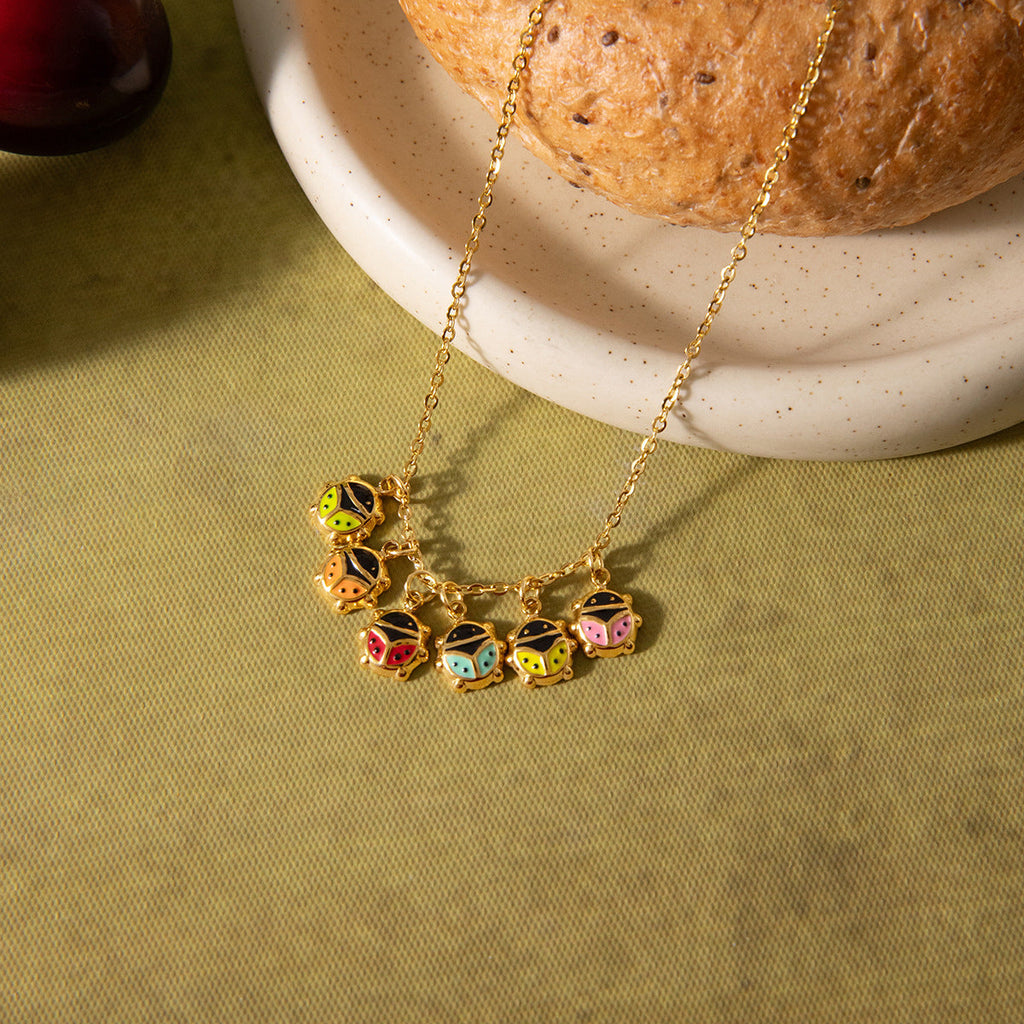 Close-up of an 18K gold ladybug pendant necklace with sparkling zircon details