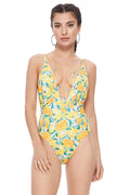 Woman wearing a textured yellow lemon print one piece swimsuit with mesh inserts and V-neckline