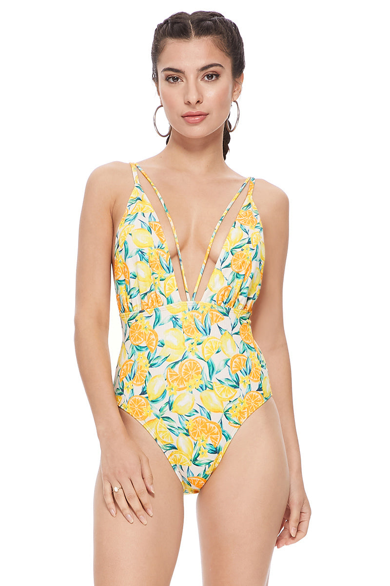 Woman wearing a textured yellow lemon print one piece swimsuit with mesh inserts and V-neckline