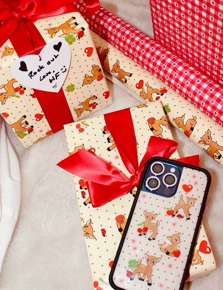 A two-pack of gift wrapping paper featuring an 'Oh Deer' fawn pattern with polka dots and a red gingham pattern with hearts.