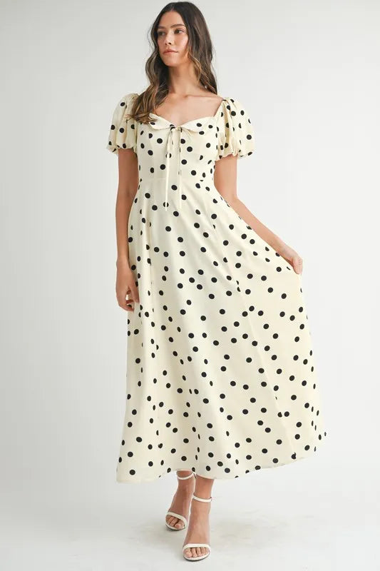 Woman wearing a vintage-style polka dot midi dress with feminine puff sleeves.
