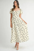Woman wearing a vintage-style polka dot midi dress with feminine puff sleeves.