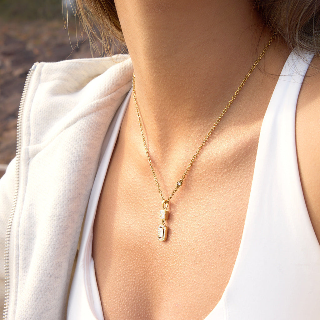 Minimalist gold square zircon pendant necklace on a stainless steel chain, displayed against a clean background.
