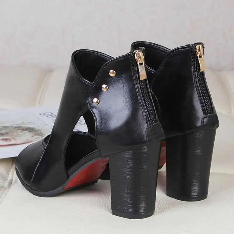 A pair of black and tan women's mid-heel cutout sandals featuring a peep-toe and back zipper closure on a white surface.