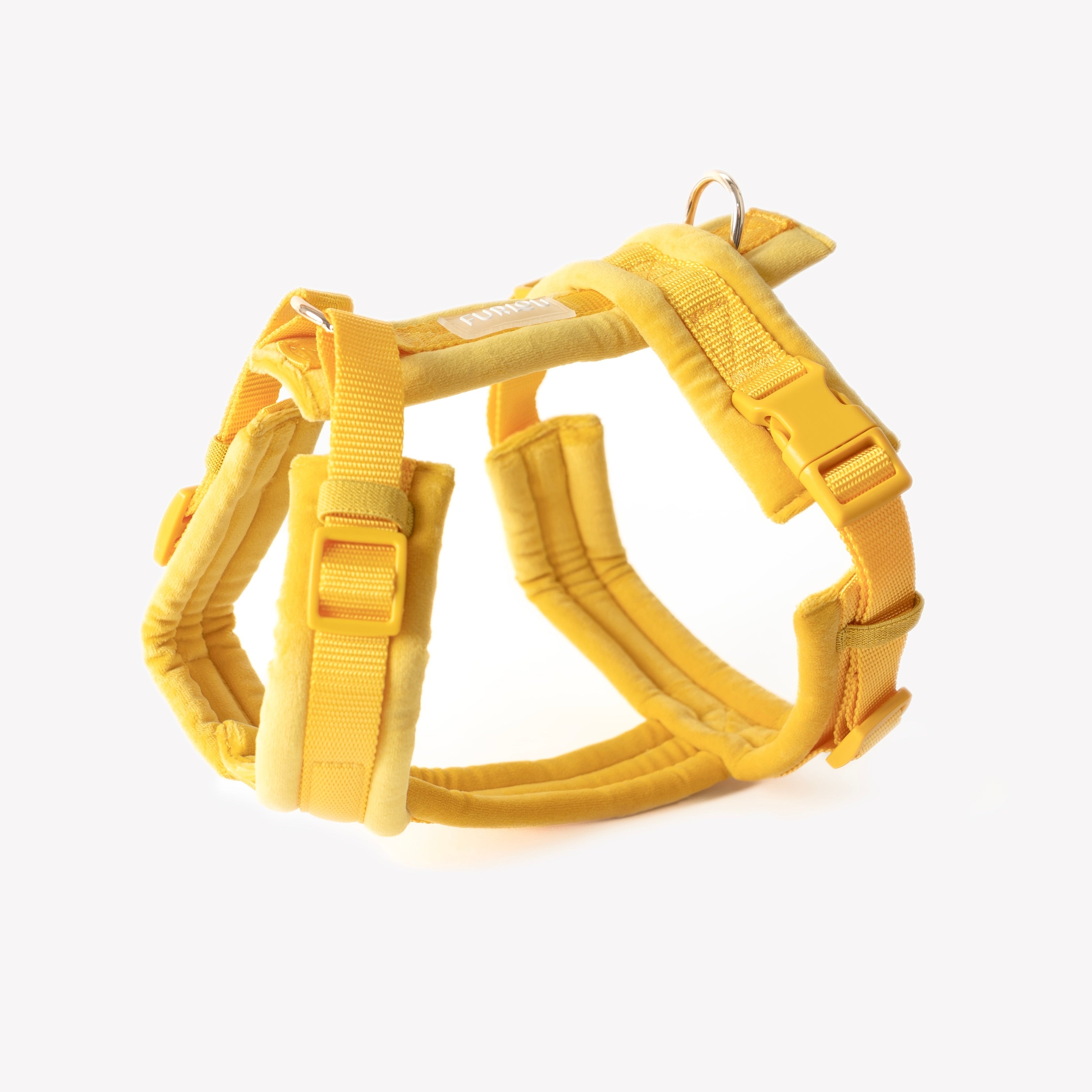 A vibrant yellow velvet dog harness with adjustable straps and gold-toned D-ring hardware against a white background.