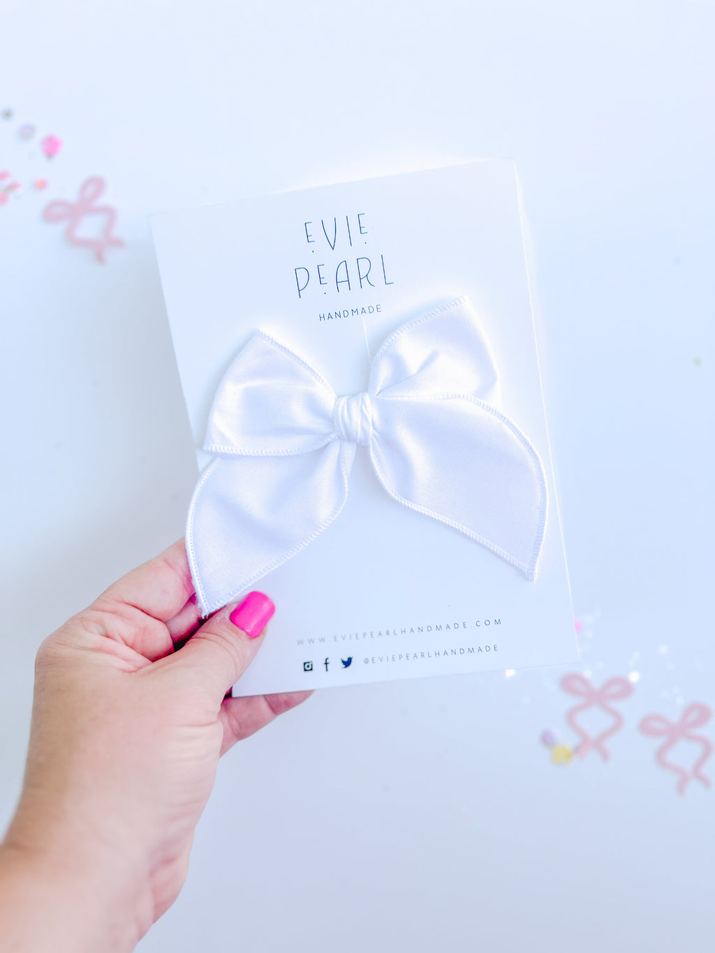 White medium-sized hair bow displayed on branded Evie Pearl Handmade packaging