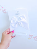 White medium-sized hair bow displayed on branded Evie Pearl Handmade packaging