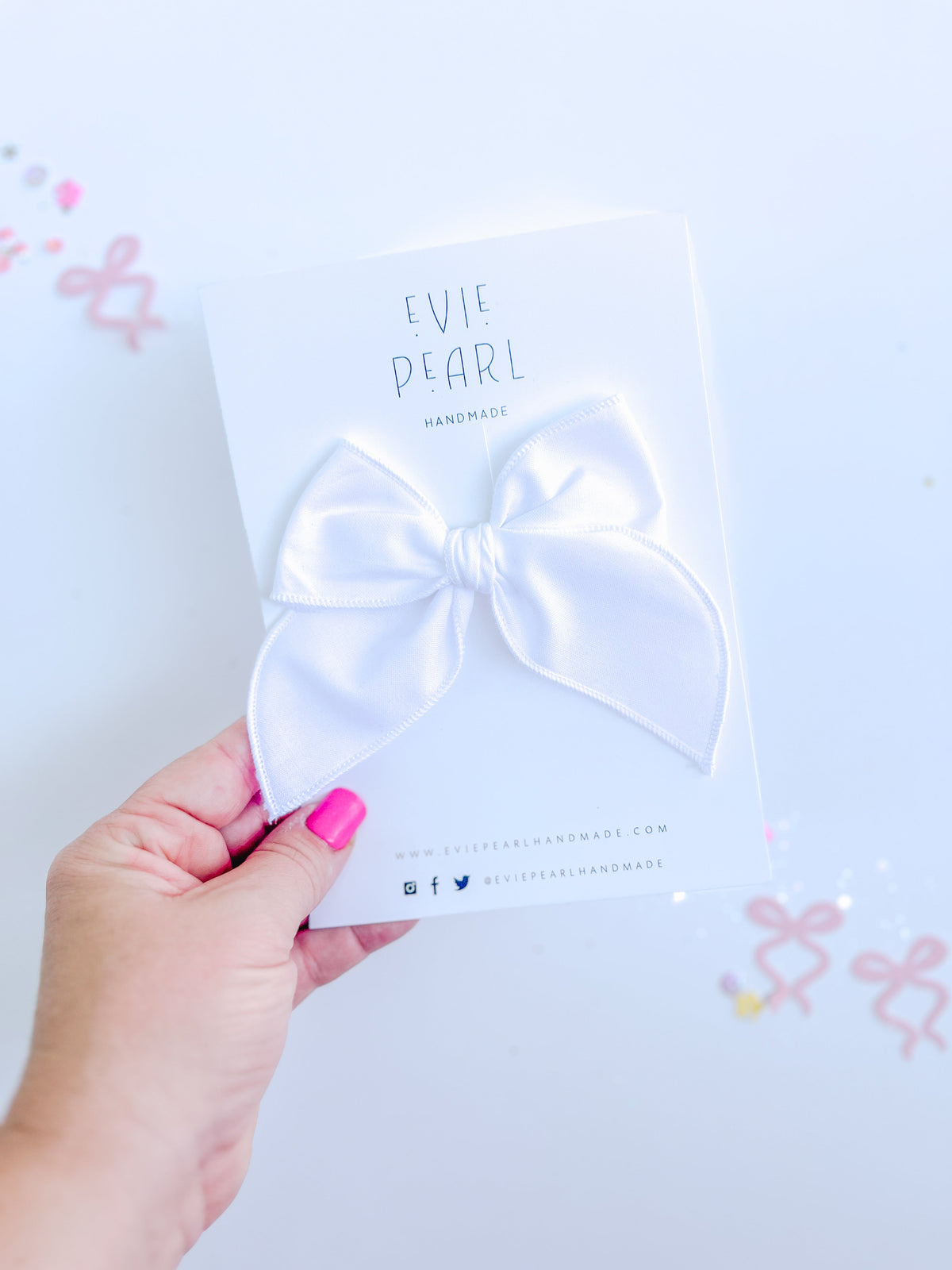 White medium-sized hair bow displayed on branded Evie Pearl Handmade packaging