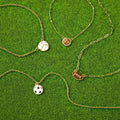 Stainless steel necklace with a sports ball pendant featuring colorful enamel detailing.