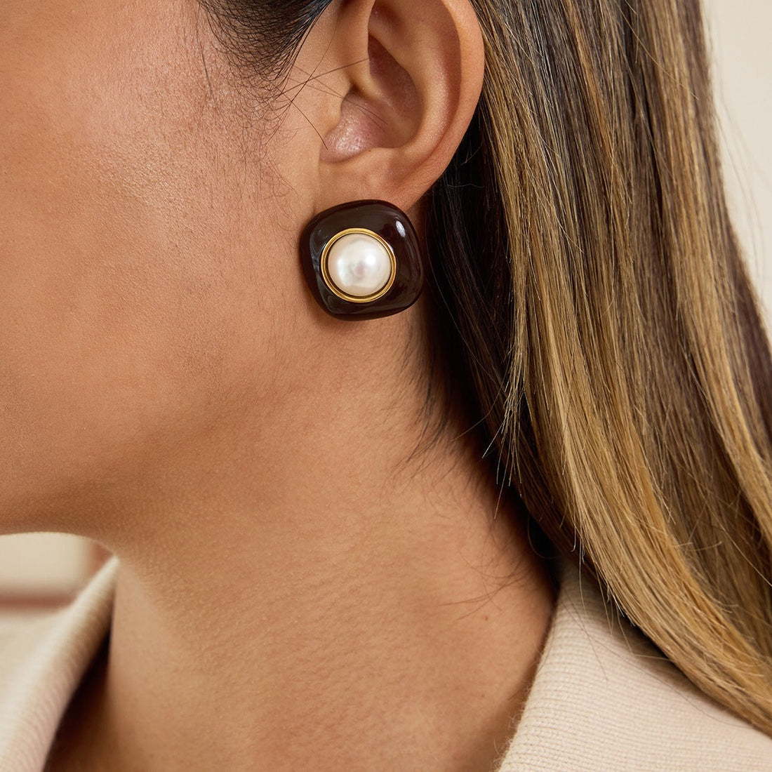 Gold-plated stud earrings featuring white pearl and enamel detail