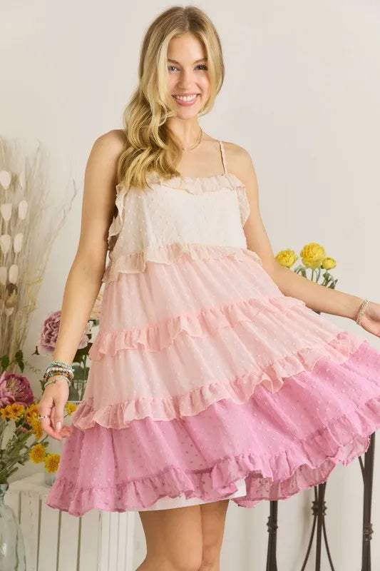 A feminine Swiss dot ruffled tiered mini dress in soft colors for a summer bohemian aesthetic