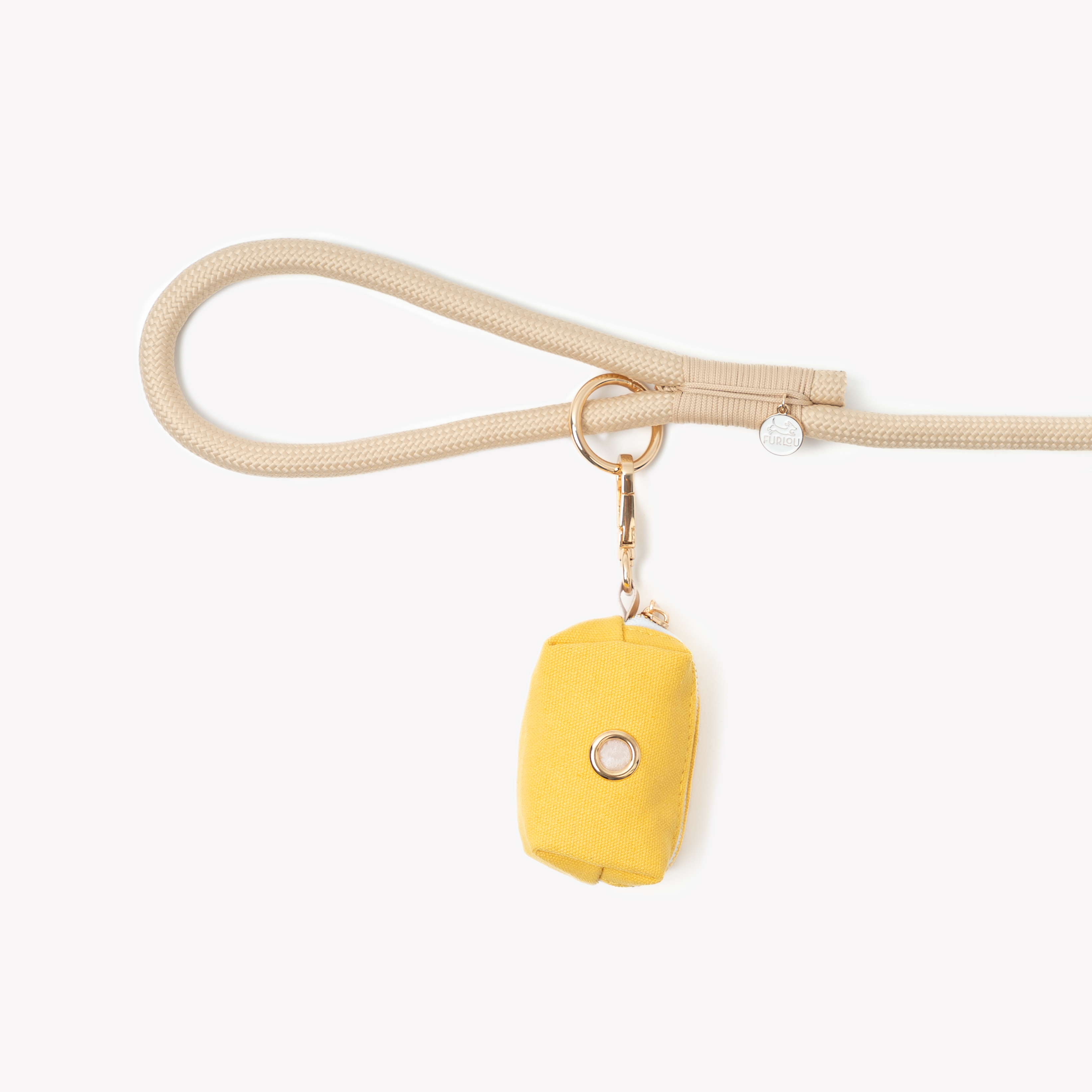 A yellow canvas poop bag holder pouch with a gold clip hanging from a beige dog leash.