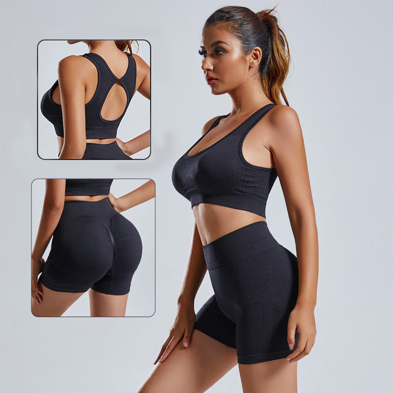 Model wearing a black two-piece seamless yoga set consisting of a vest top and athletic shorts