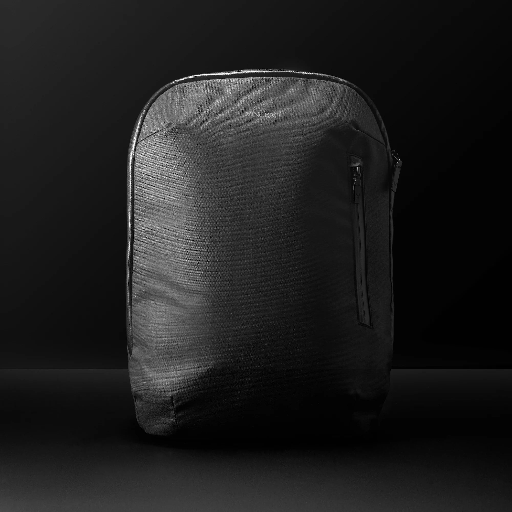 A sleek black Vincero Collective Commuter backpack in the Stealth colorway, shown from a front-facing perspective.