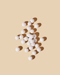 White spherical scent diffusing ceramic beads displayed on a neutral background