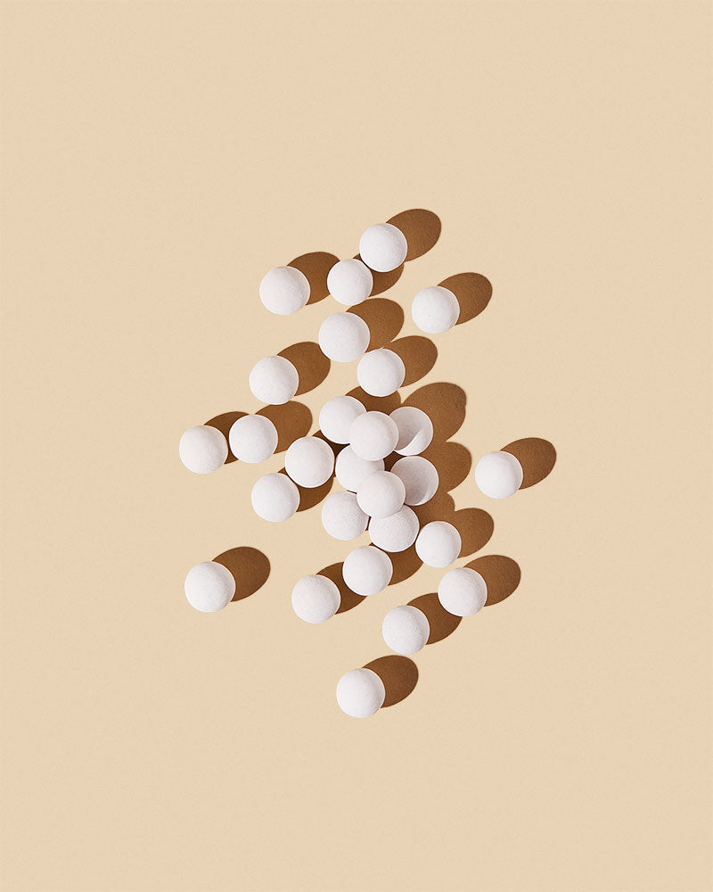 White spherical scent diffusing ceramic beads displayed on a neutral background
