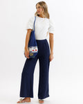 Model wearing dark blue wide leg Parisian pants with a back elastic waistband and side stripe detail