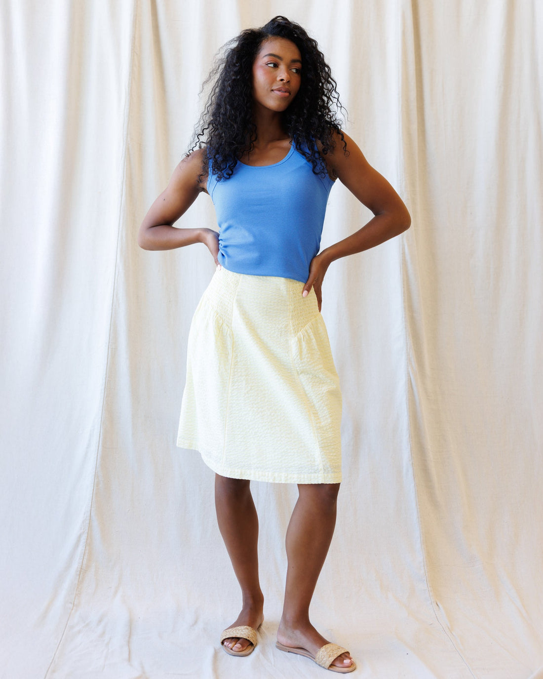 A light yellow and white jacquard check cotton skirt with a versatile smocked waistband for a preppy, classic aesthetic.