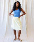 A light yellow and white jacquard check cotton skirt with a versatile smocked waistband for a preppy, classic aesthetic.