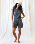 Women wearing charcoal grey wide-leg knit shorts with white dot pattern, featuring front pleats and slant pockets.