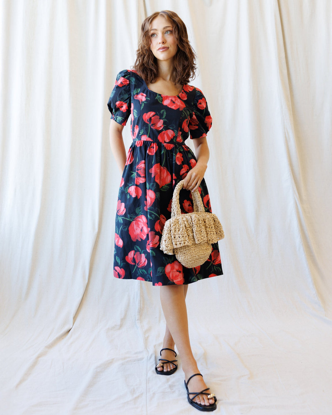 Woman wearing a floral A-line Signature Sun Dress with bubble sleeves and a keyhole scoop neckline.