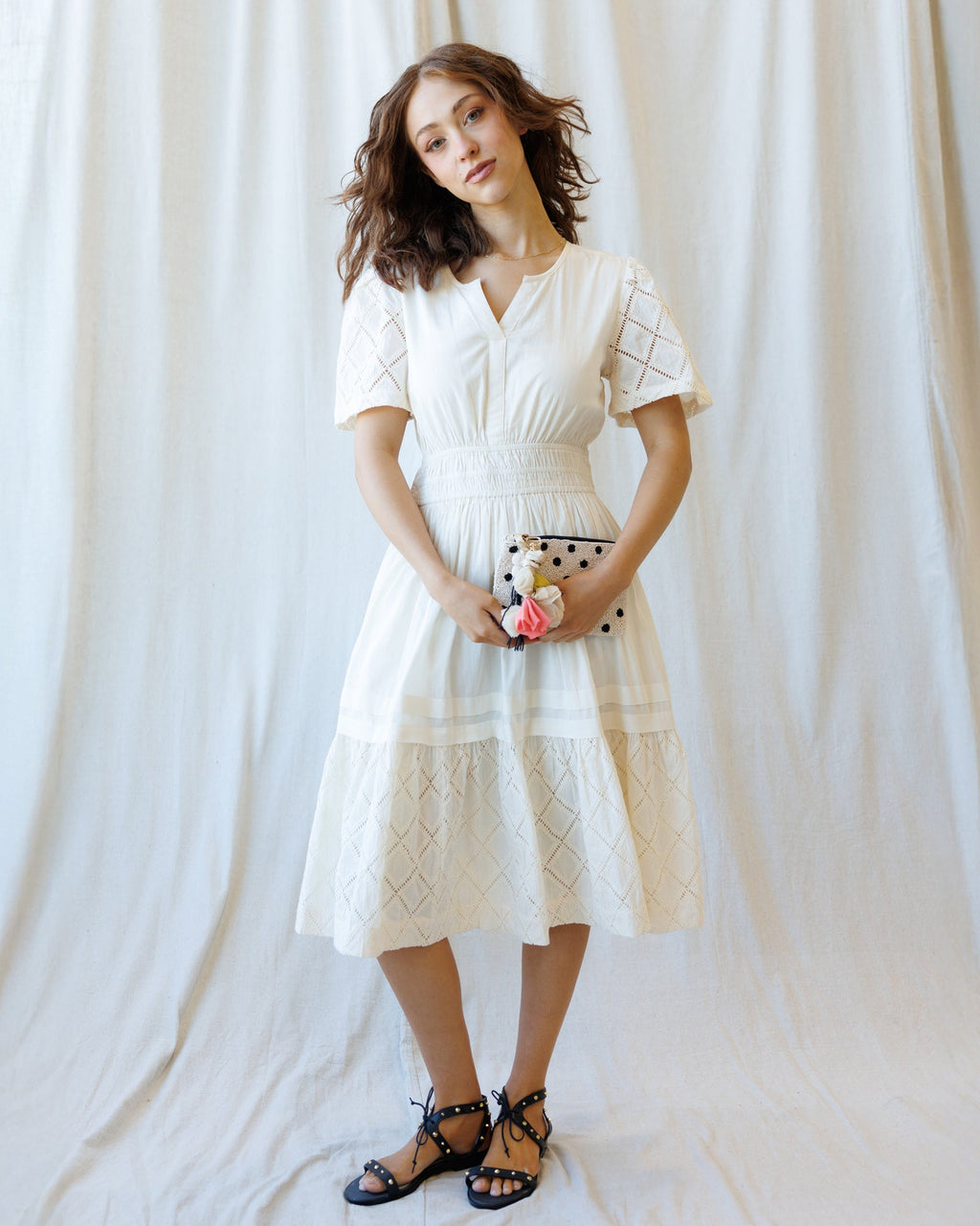 Model wearing a white romantic lace midi dress with V-neck, short sleeves, and A-line silhouette.