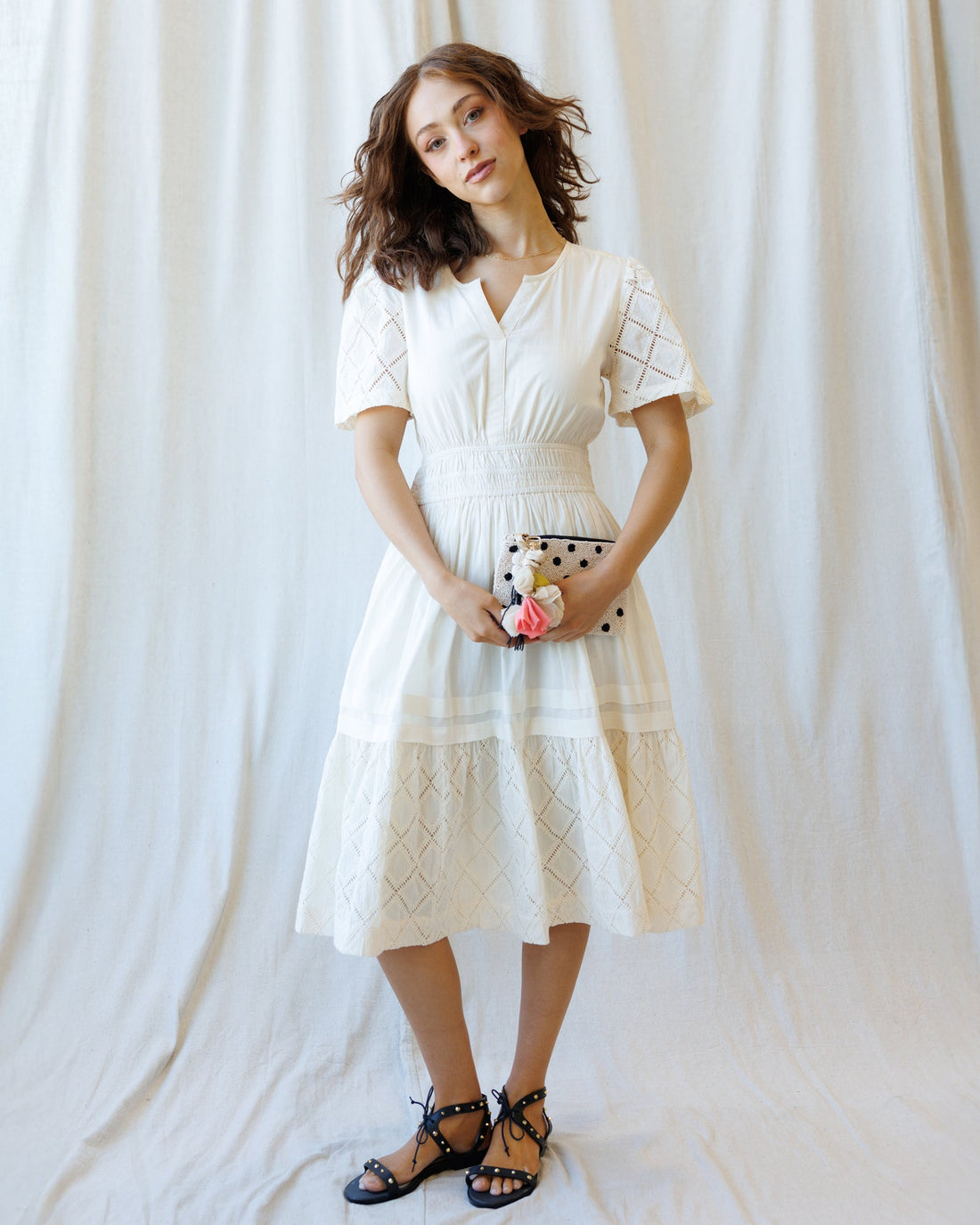 Model wearing a white romantic lace midi dress with V-neck, short sleeves, and A-line silhouette.