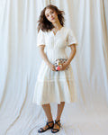 Model wearing a white romantic lace midi dress with V-neck, short sleeves, and A-line silhouette.