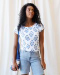 Close up of woman wearing a white and blue floral block-print tee with an envelope neckline