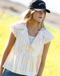 Woman wearing a yellow and white striped peplum top with a tie front and notched collar