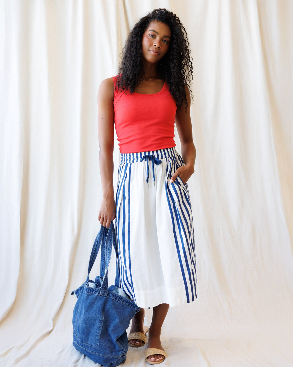 White and blue striped A-line midi skirt with an elastic drawstring waist, styled for a nautical, coastal-grandmother look.