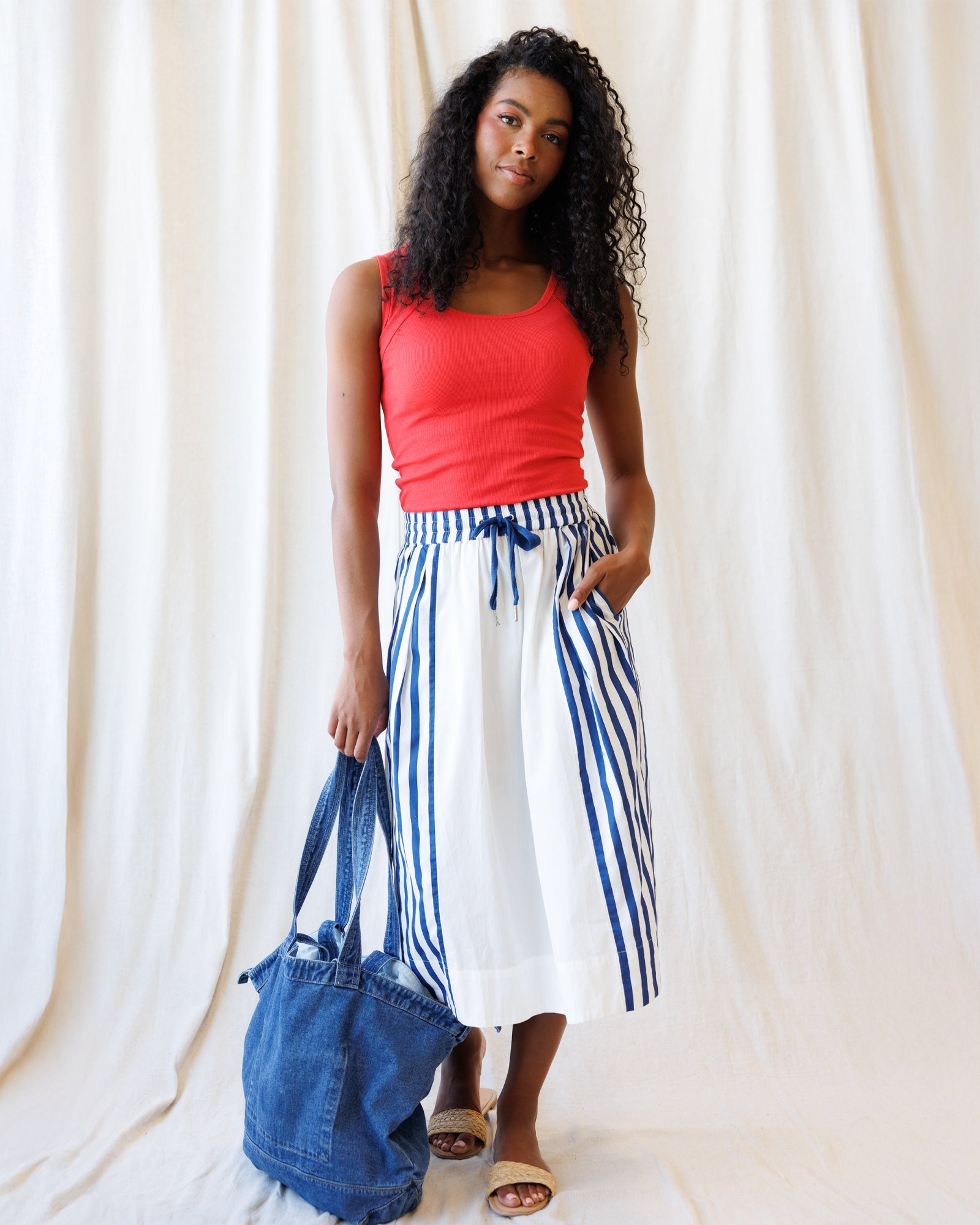 White and blue striped A-line midi skirt with an elastic drawstring waist, styled for a nautical, coastal-grandmother look.