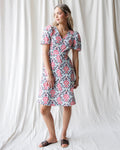 Woman wearing a cotton A-line Capri dress with puff sleeves and a button-down front