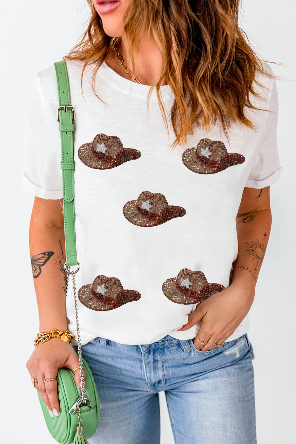 Model wearing a white short sleeve t-shirt with brown sequin cowboy hat designs