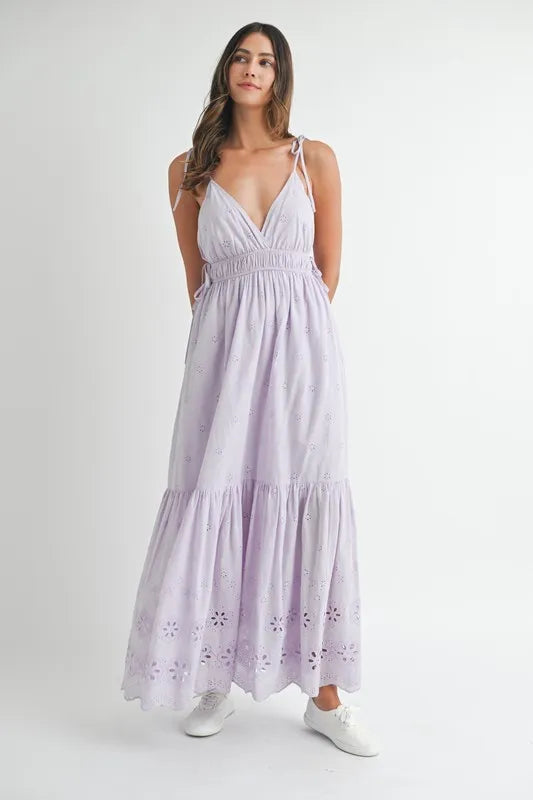 Woman wearing a light-purple eyelet lace maxi dress with side strap details