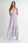 Woman wearing a light-purple eyelet lace maxi dress with side strap details