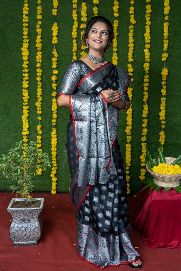 Chic black soft handloom silk saree with zari woven borders and matching blouse.