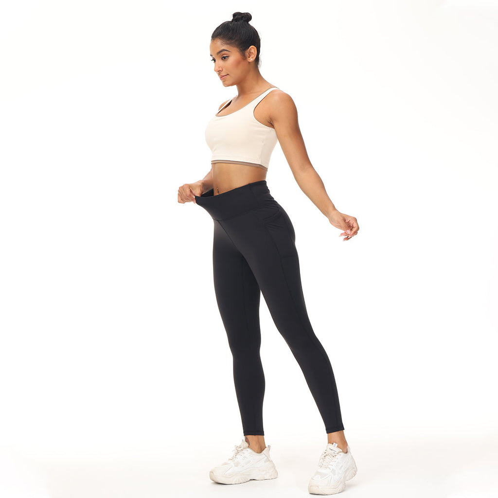 Model wearing black high-waisted athletic slim leggings with a white sports bra