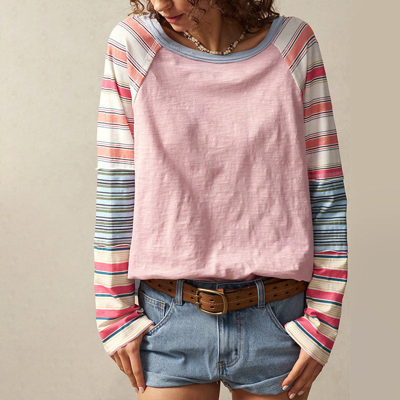 A woman wearing a long sleeve round neck top with multicolored striped patchwork design.