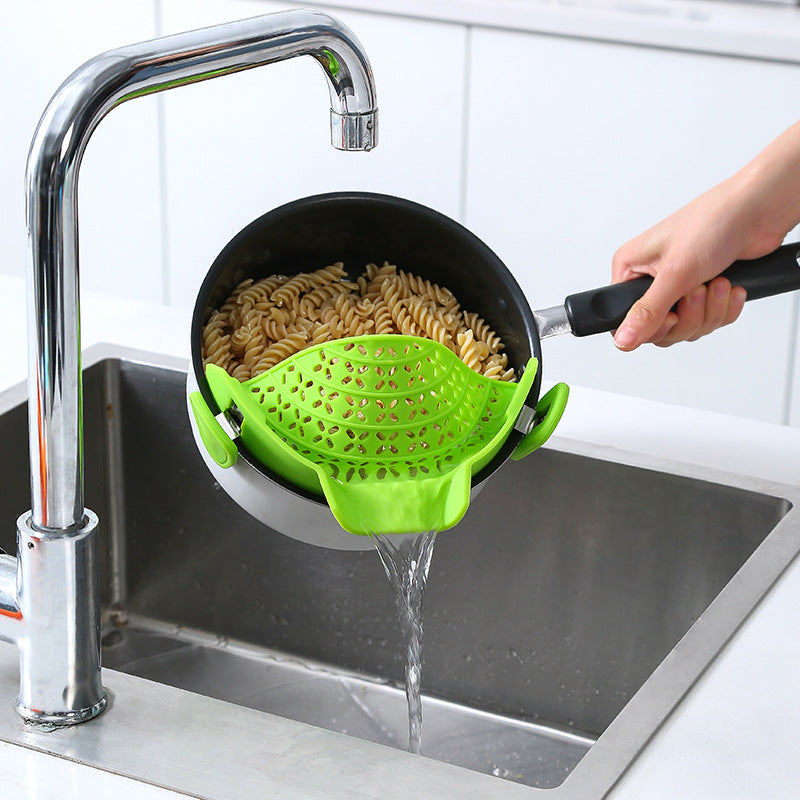 Silicone pot side drainer in various colors attached to a pot for draining water