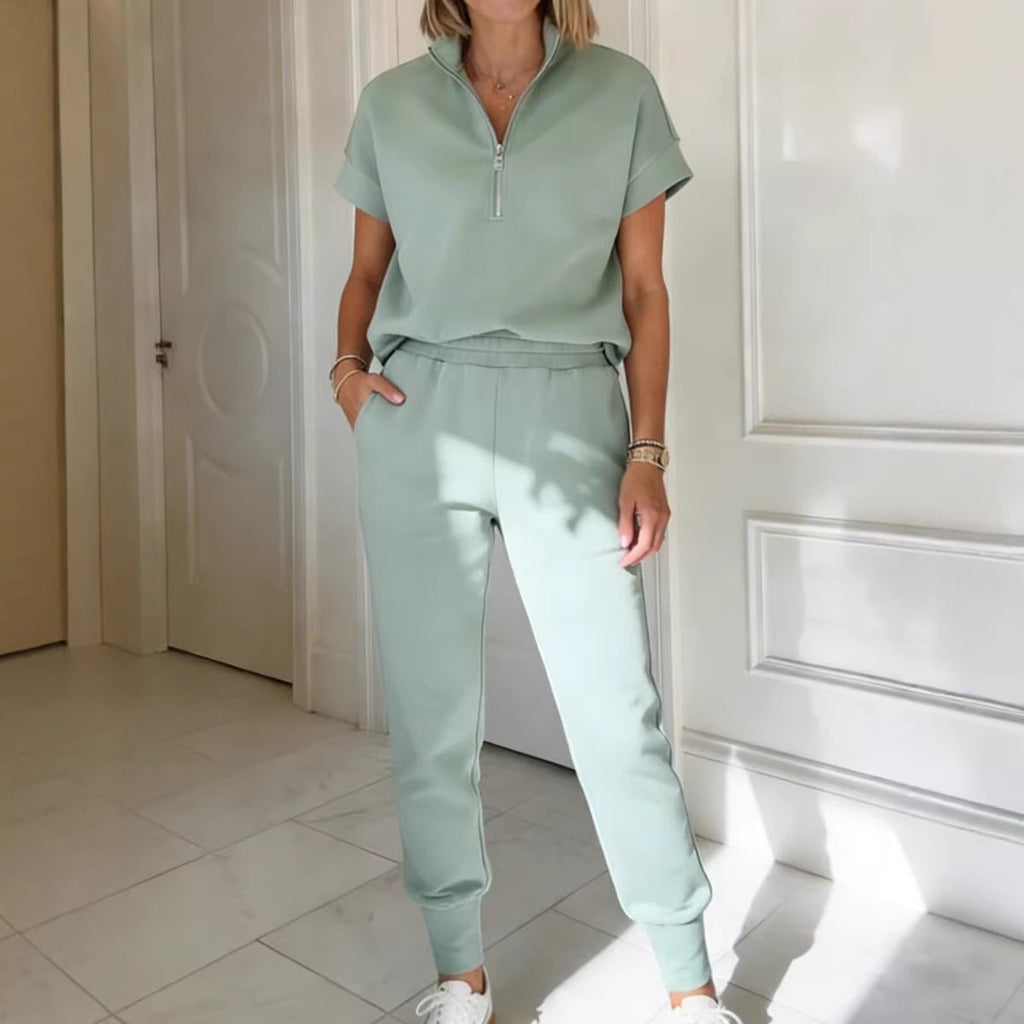Woman wearing a light green short sleeve quarter-zip top and matching slim-fit jogger pants