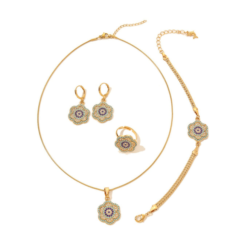 Gold-tone Turkish evil eye jewelry set with flower-shaped blue enamel charms including a necklace, bracelet, and earrings.